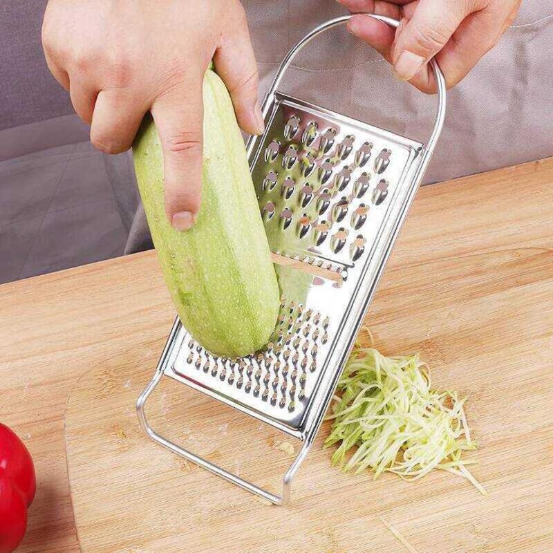 This may contain: a person grating green vegetables with a grater on a cutting board next to tomatoes