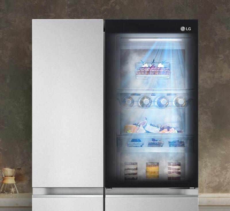 ตู้เย็น LG ประตูใสด้านขวา แสดงอาหารในแสงไฟสว่าง ติดตั้งในครัวที่ตกแต่งด้วยสีเอิร์ธโทน