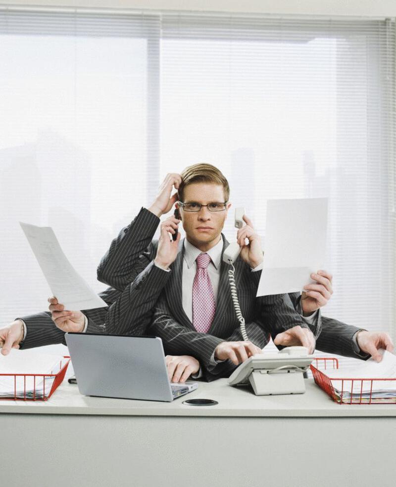 This may contain: two men in suits sitting at a table with laptops and phones on their heads