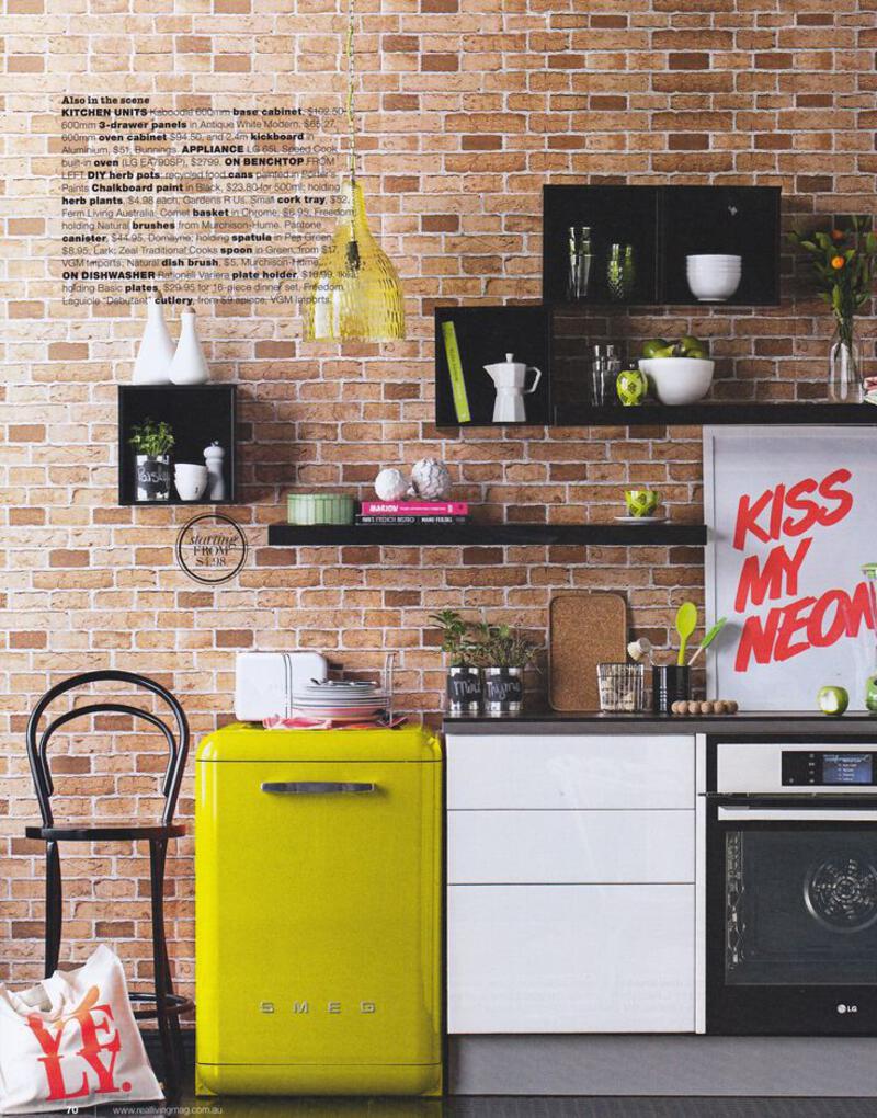 This may contain: an open magazine showing a kitchen with brick walls and white cabinets, yellow refrigerator and stove