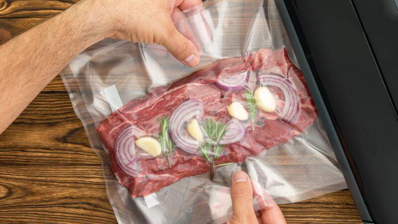 This may contain: a person holding a piece of meat with onions on it