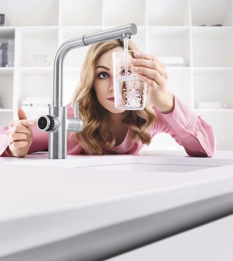 This may contain: a woman is drinking water from a faucet