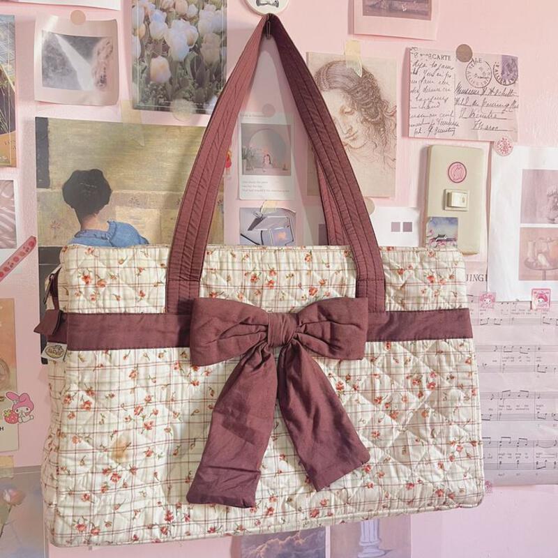 This may contain: a purse with a bow hanging from it