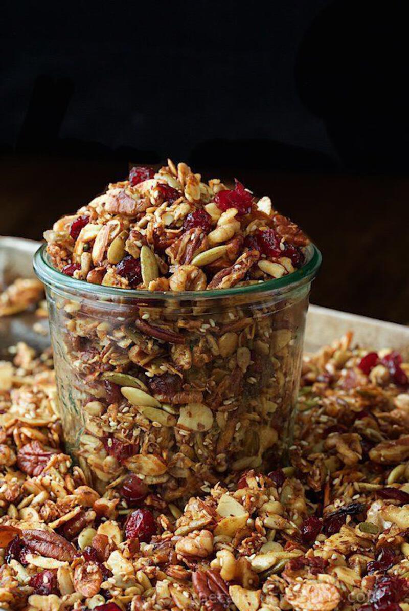 This may contain: a glass jar filled with granola sitting on top of a table next to another container full of granola