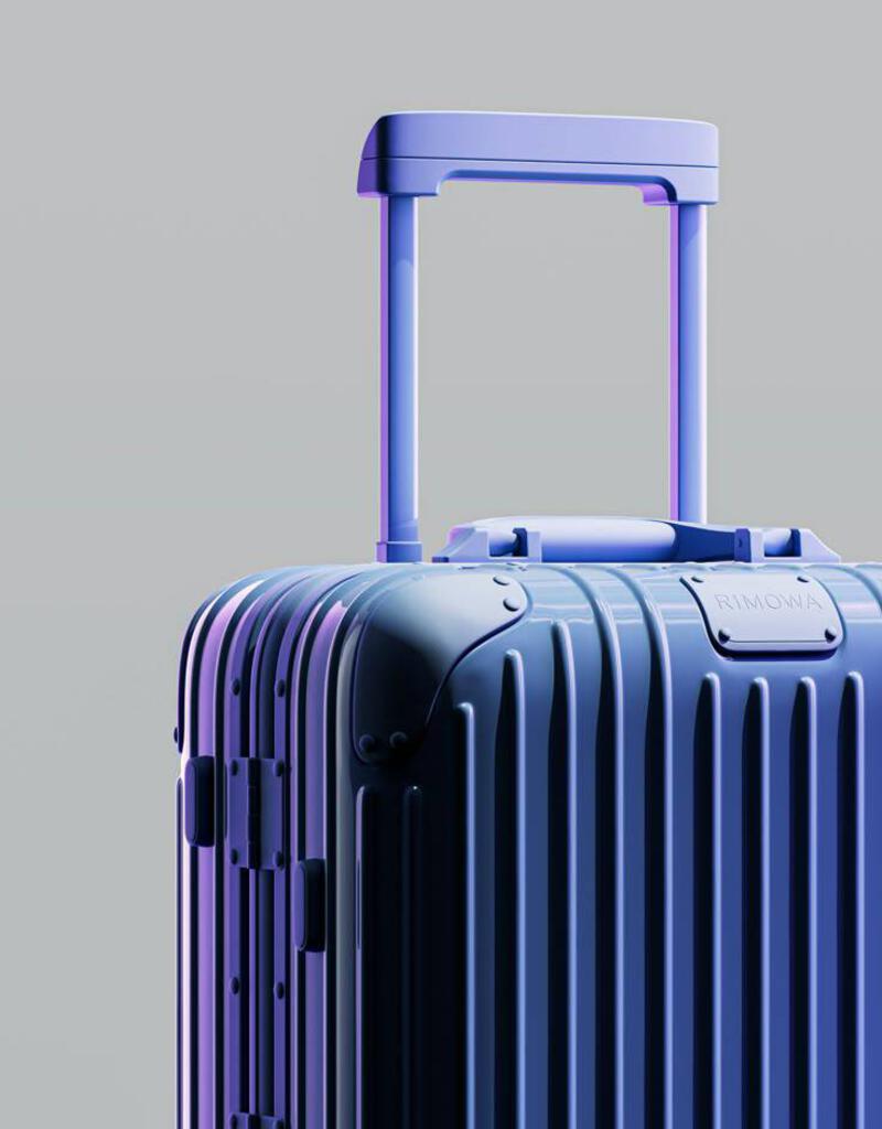 This may contain: a blue piece of luggage sitting on top of a white floor next to a gray wall