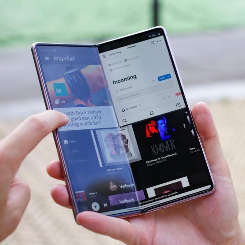 This may contain: a person holding an open cell phone in their left hand with the screen partially closed