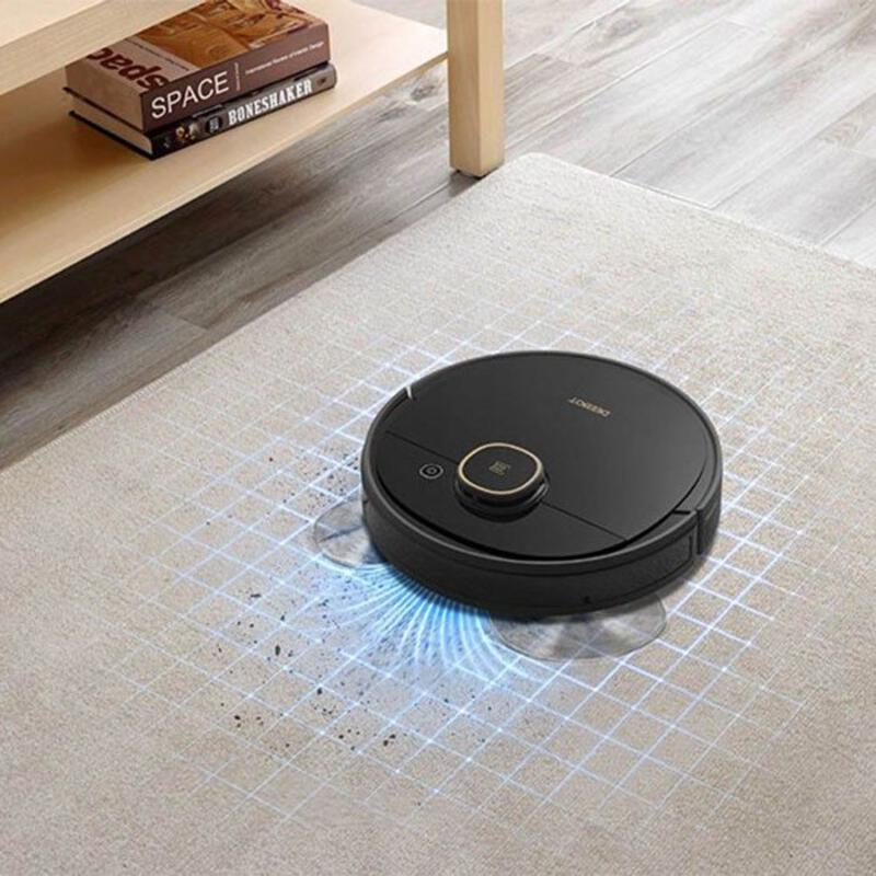 This may contain: a roomba that is on the floor in front of a coffee table with books