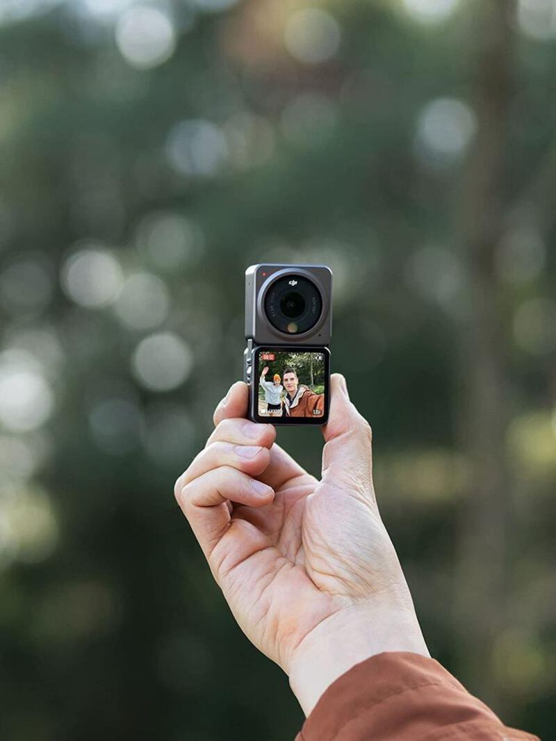 This may contain: a person holding up a camera to take a photo