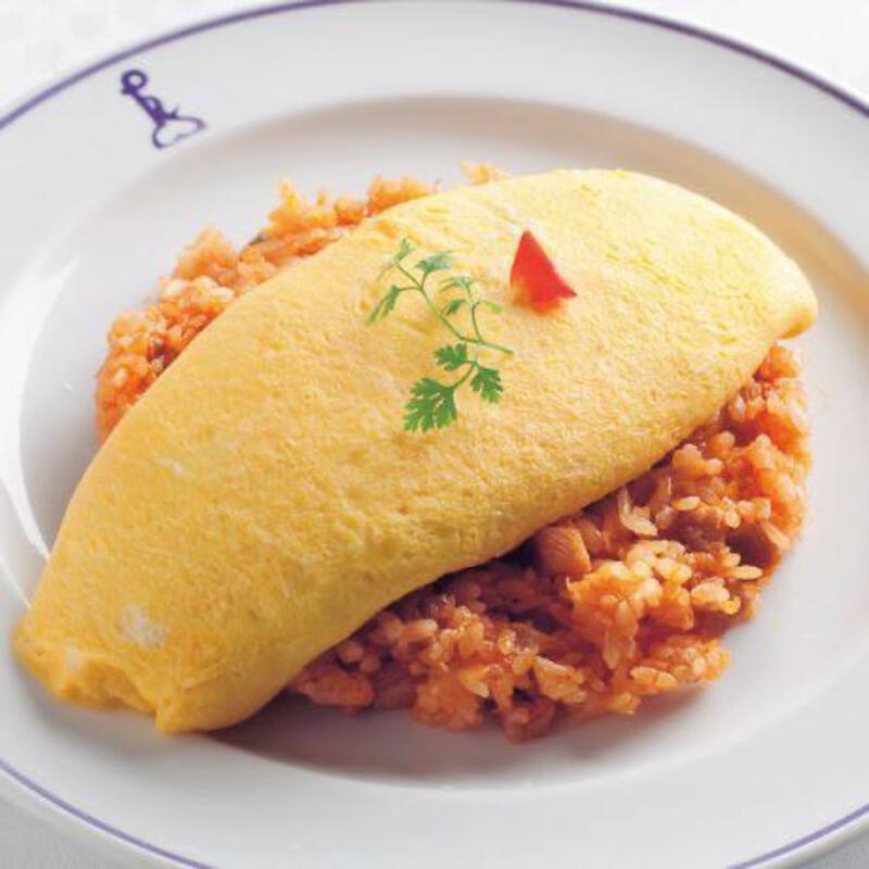 This may contain: an omelet on a plate with rice and garnish