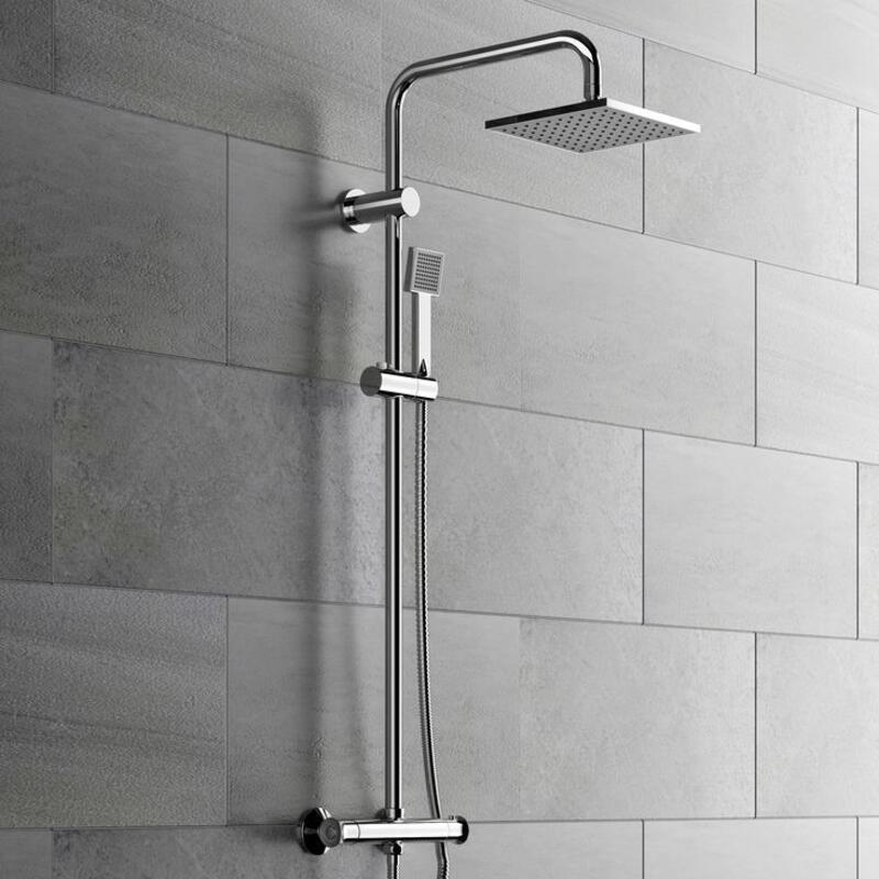 This may contain: a shower head with thermostaer and handset in front of a tiled wall
