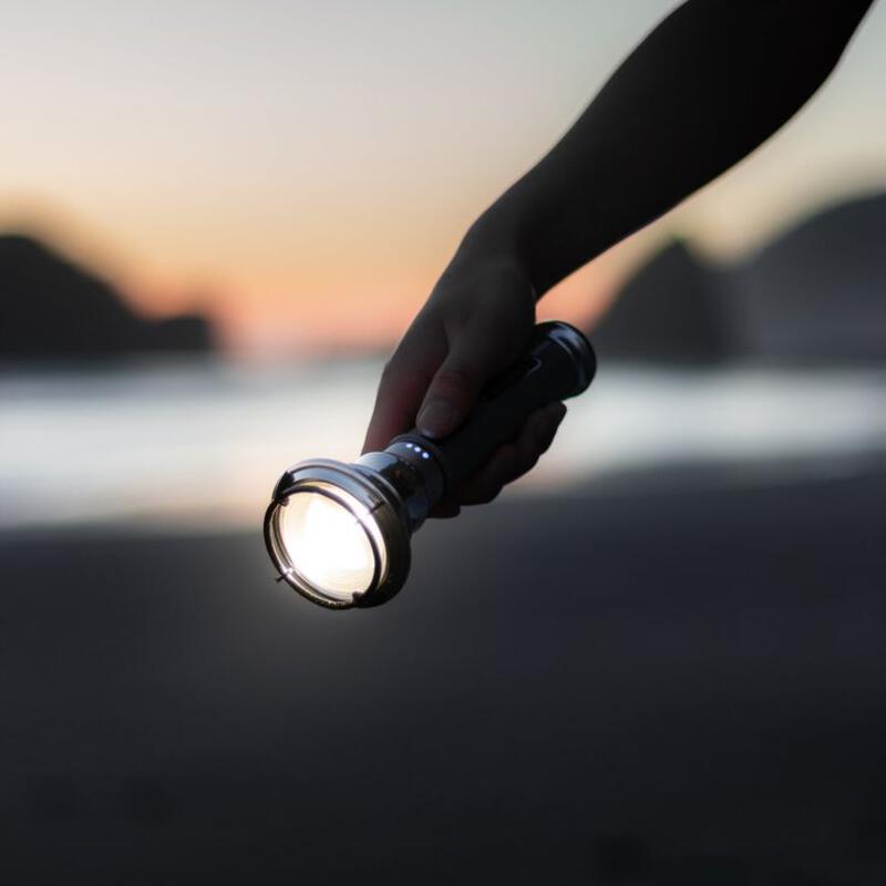 This may contain: a person holding a flashlight in their hand