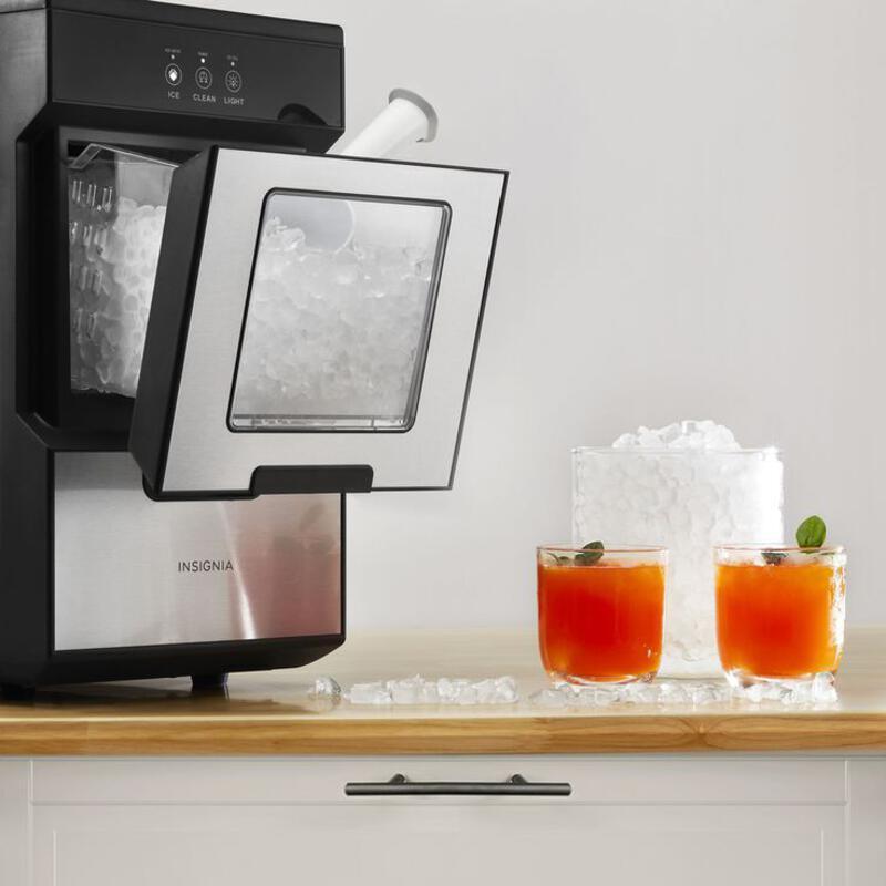 This may contain: an ice maker with two glasses on the counter next to it and another beverage machine
