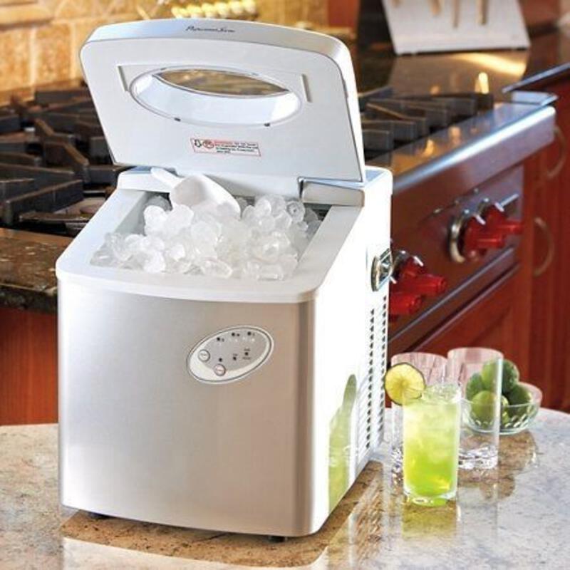 This may contain: a small ice maker sitting on top of a kitchen counter next to cups and glasses