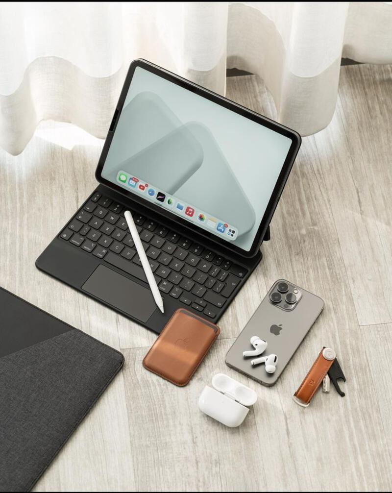 This may contain: an open laptop computer sitting on top of a wooden table next to ear buds and headphones