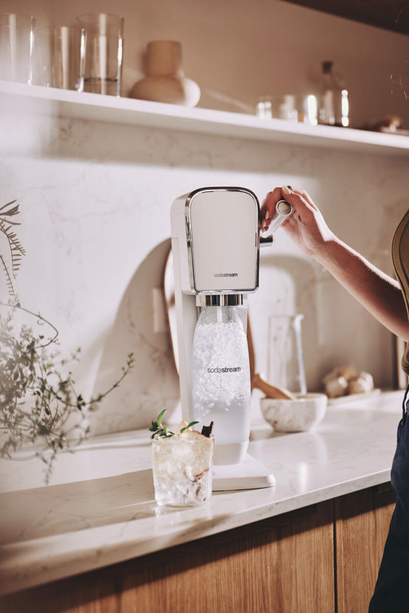This may contain: a woman is pouring water into a blender
