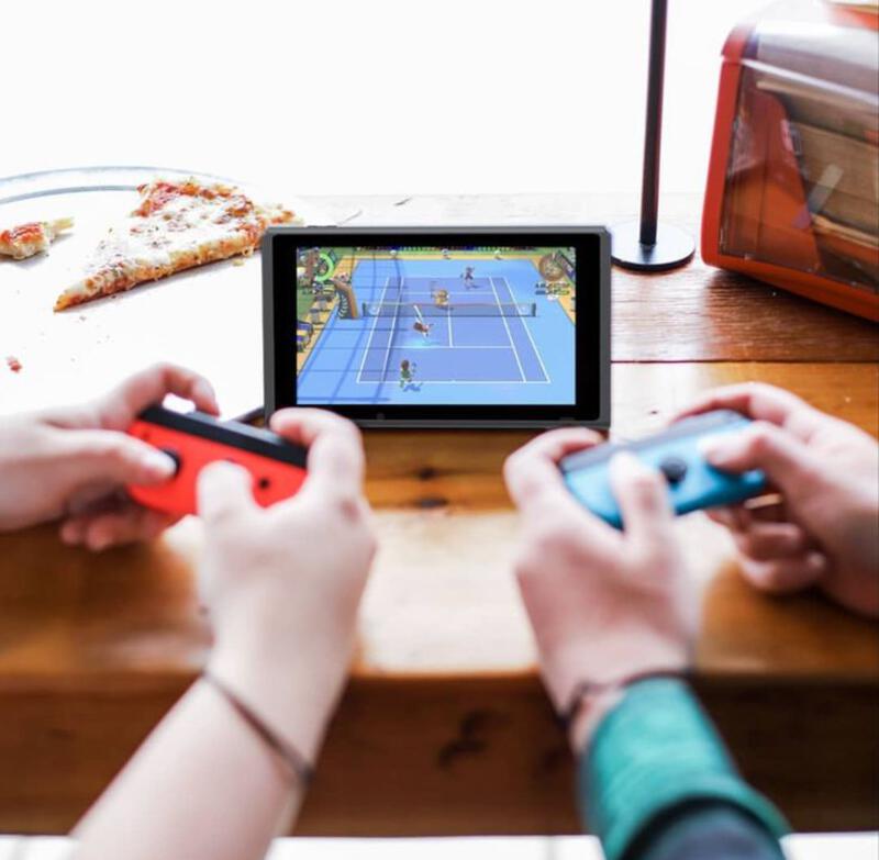 This may contain: two people playing a video game with nintendo wii controllers in front of pizza slices on a table