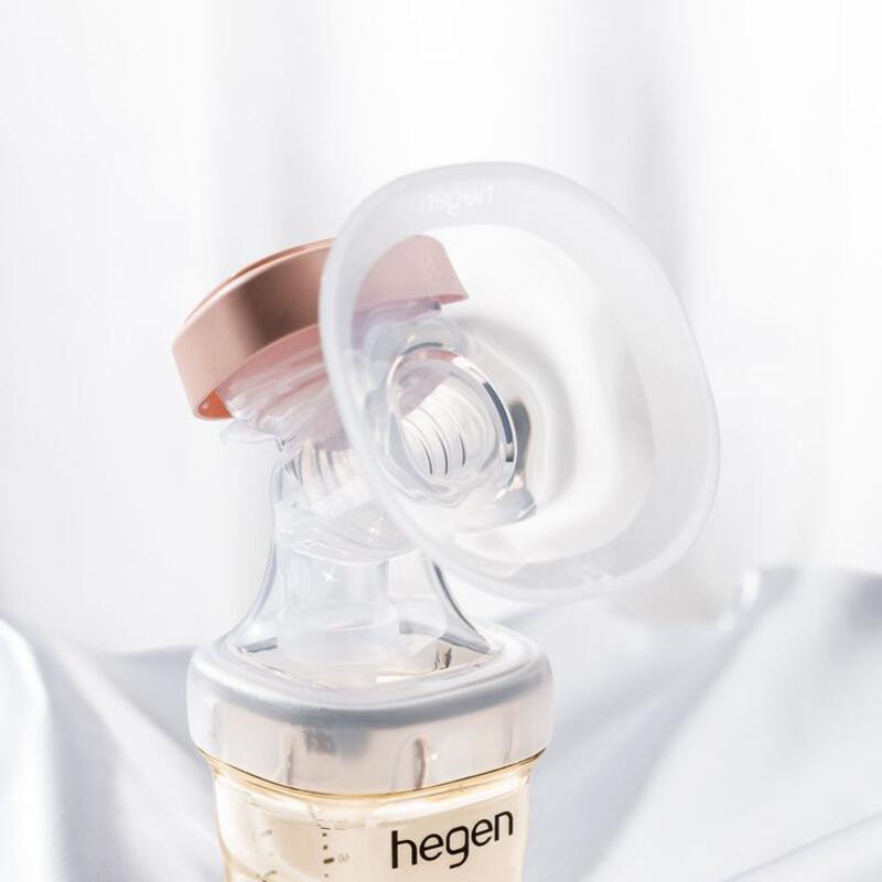 This may contain: a bottle with a breast pump attached to it on a white cloth covered tablecloth