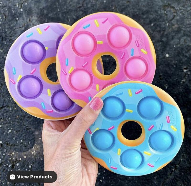 This may contain: two doughnuts with sprinkles on them being held by a person