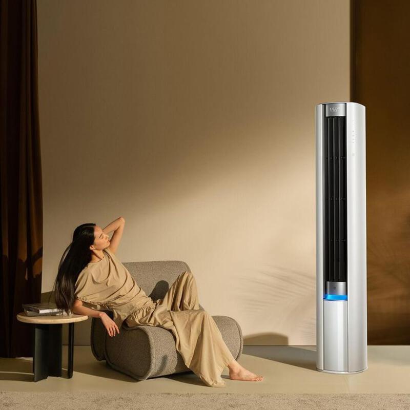 This may contain: a woman sitting on a couch next to an air purifier