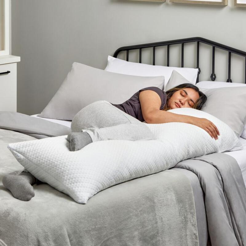 This may contain: a woman is sleeping in her bed with pillows