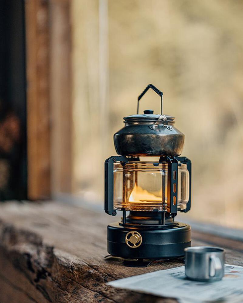 This may contain: a lantern sitting on top of a wooden table