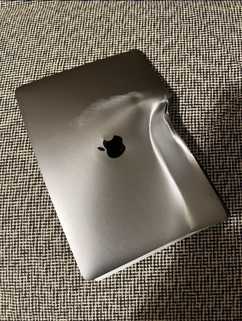 This may contain: an apple laptop sitting on top of a couch